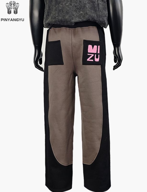 Pantalones deportivos de tela empalmada con diseño bordado