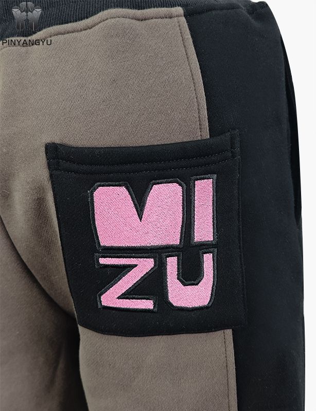 Pantalones deportivos de tela empalmada con diseño bordado